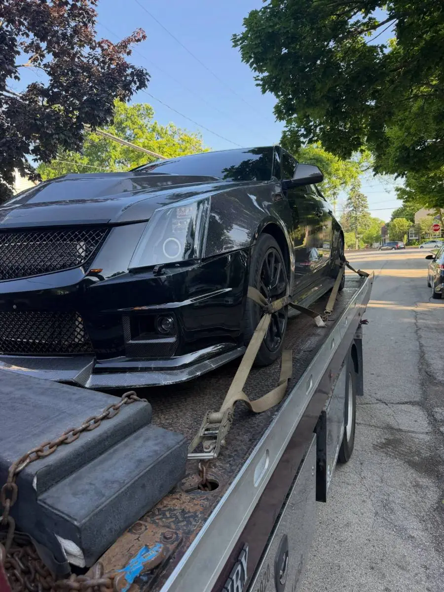 Black Cadillac secured on a PS Towing flatbed
