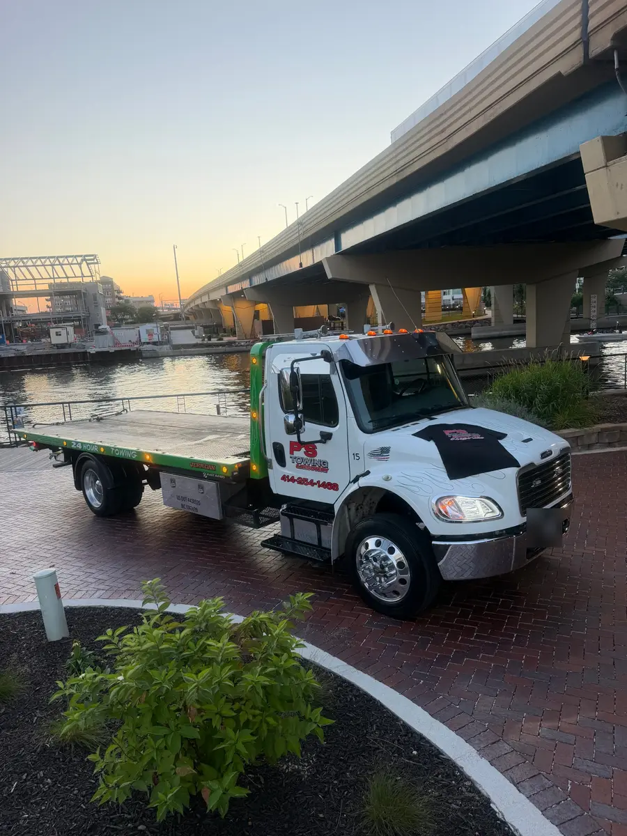 PS Towing Freightliner M2 106 flatbed tow truck on the Milwaukee riverfront at sunset